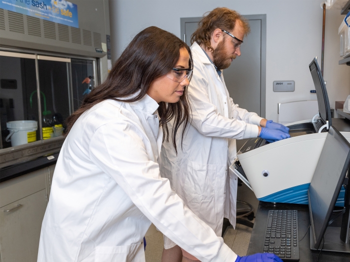 students in a lab working and wearing latex gloves 