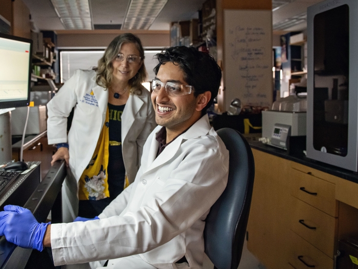 two lab students working together in research area