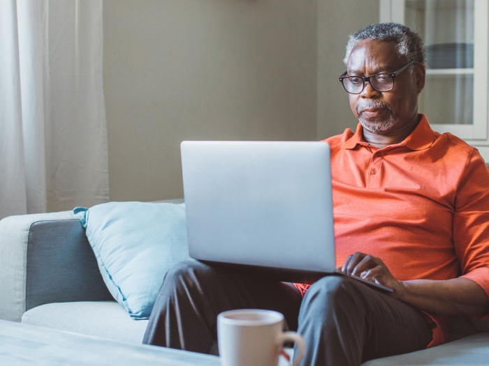 man in orange shirt sitting in living room