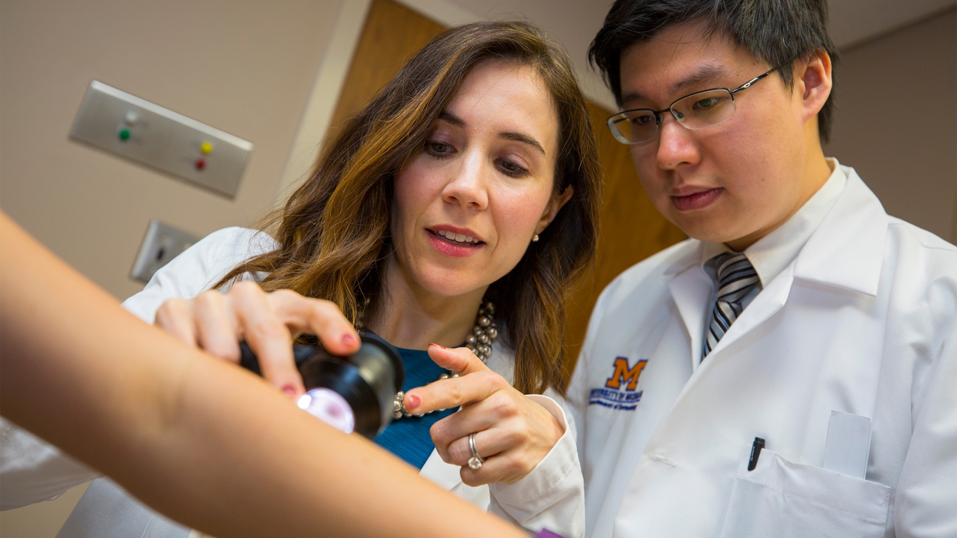 Doctors examining patient arm 