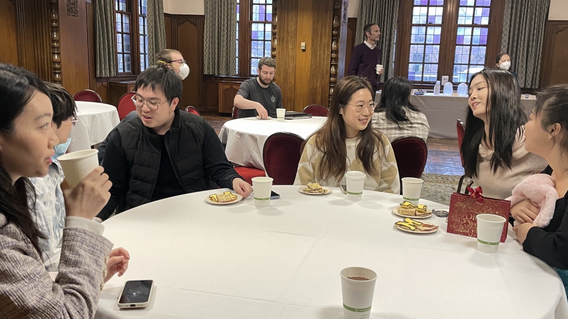  Smiling students sitting around a table.