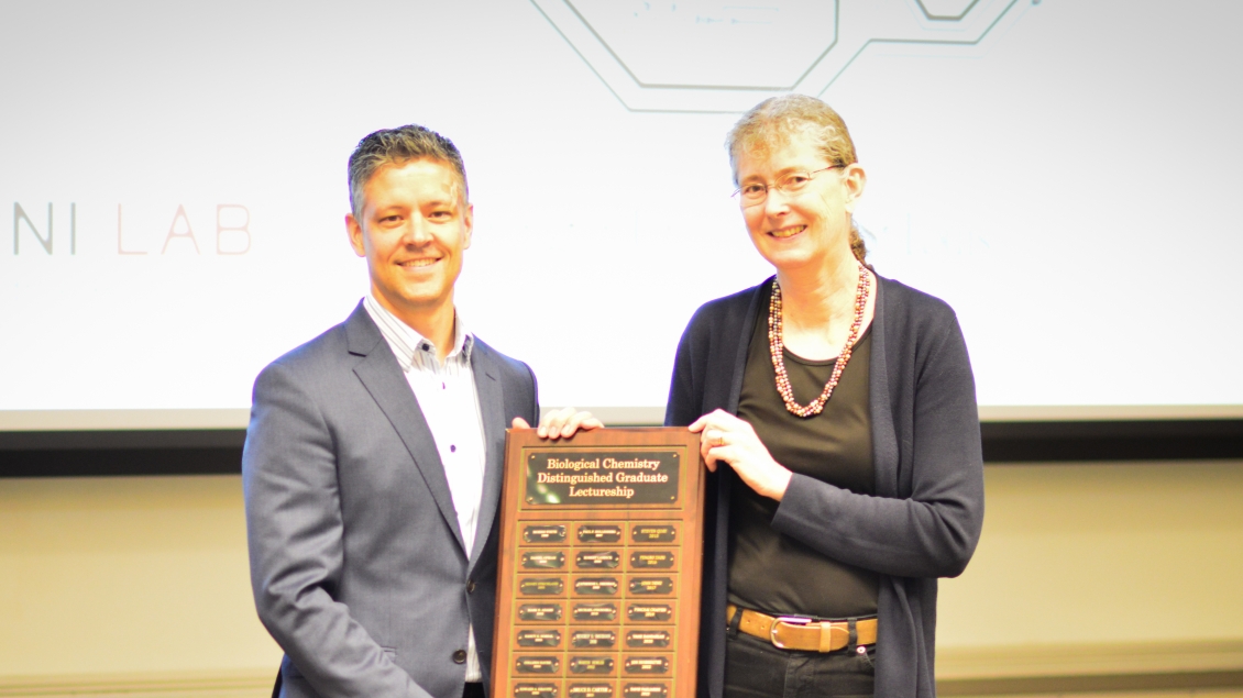 professor receiving distinguished leadership award from another colleague 