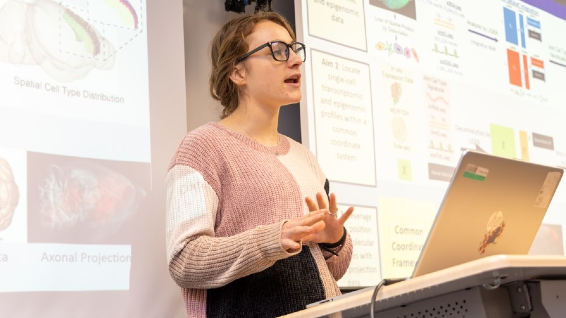 A female DCMB student presents at the podium