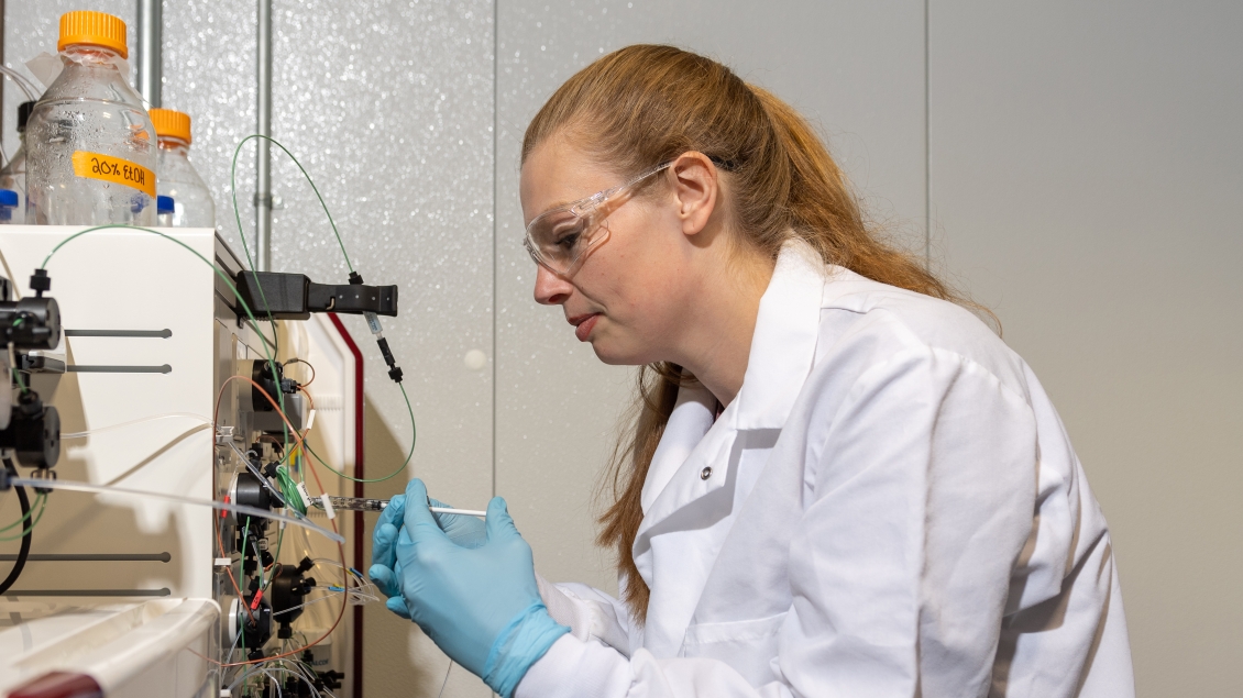 A biochemistry researcher examines a specimen in the lab