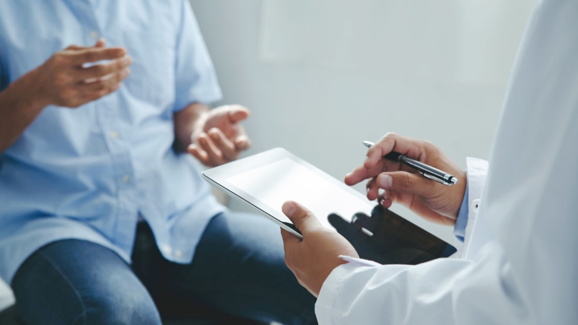 Close up of a provider taking notes while speaking to patient