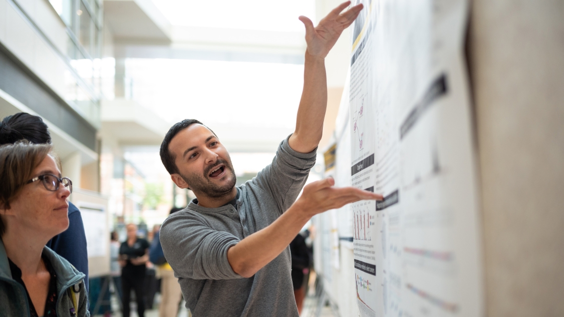 a person pointing at a poster