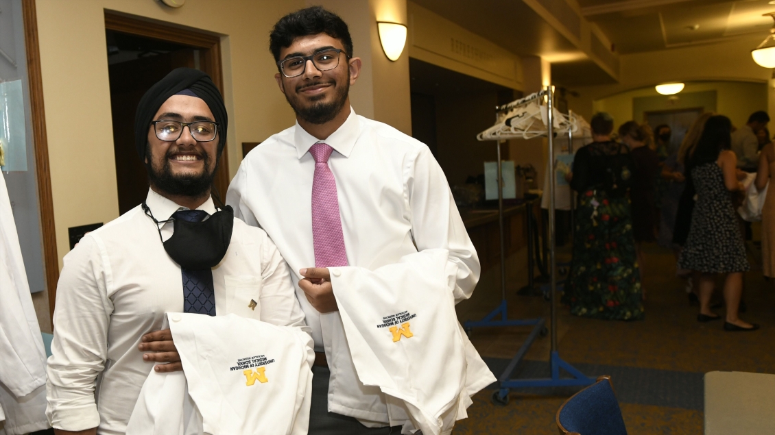 Two students with lab coats smiling