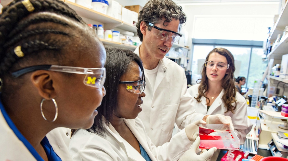 A group of students watching a demonstration in a lab