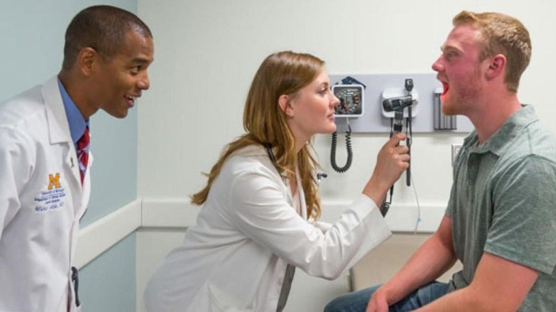 Two doctors working with a patient