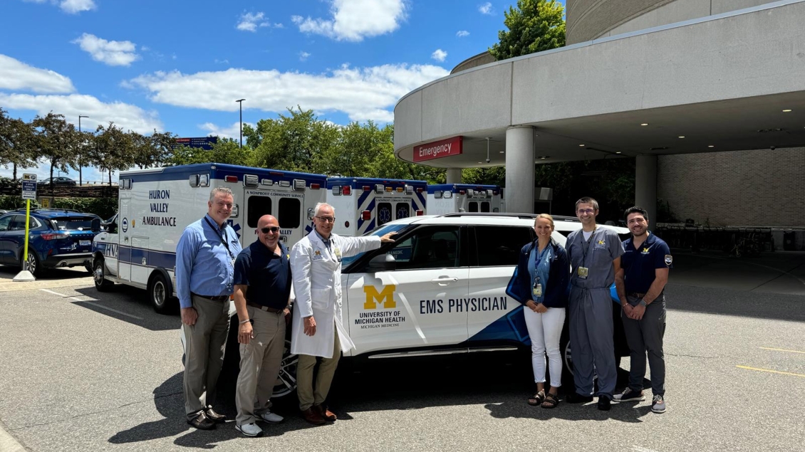 People standing in front of ems vehicle 