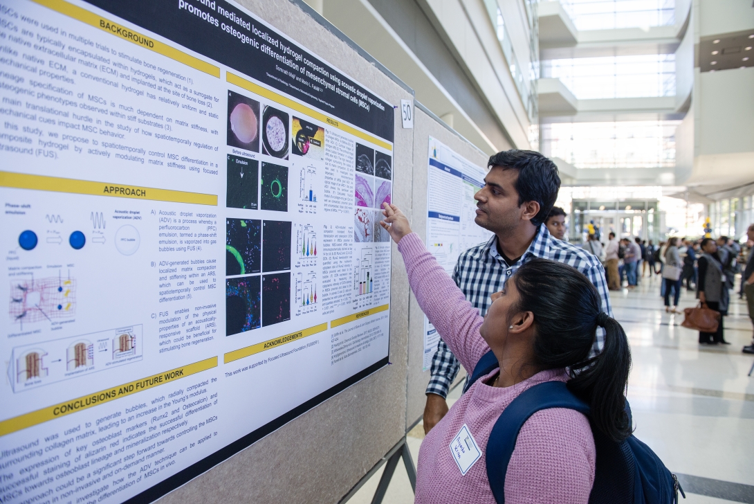 PhD students looking at a poster